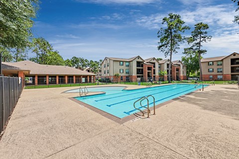 A swimming pool in front of apartment buildings.
