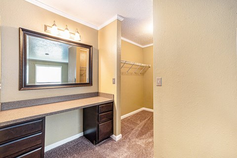 a walk in closet with a mirror and a closet hanger