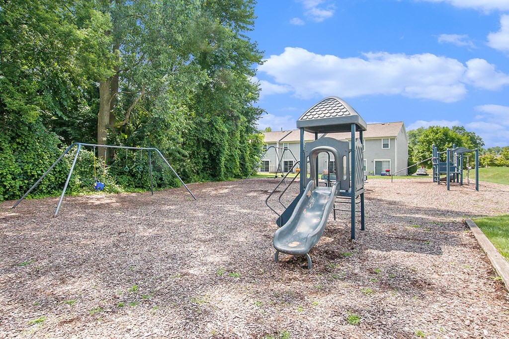 a playground with a swing set in a park