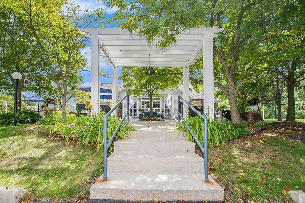 steps leading up to a white pavilion with trees