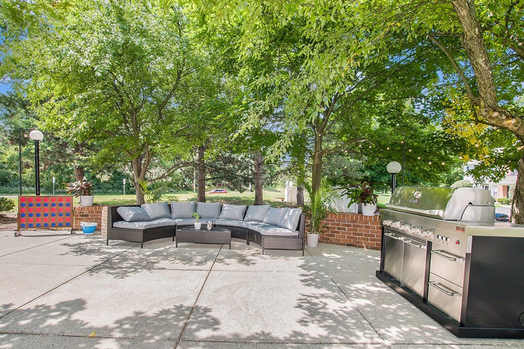 a backyard with a couch and a grill and a barbecue