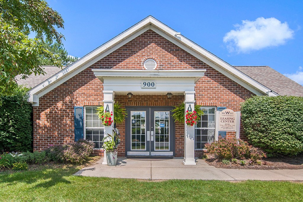 the front of a brick building with two doors and a porch