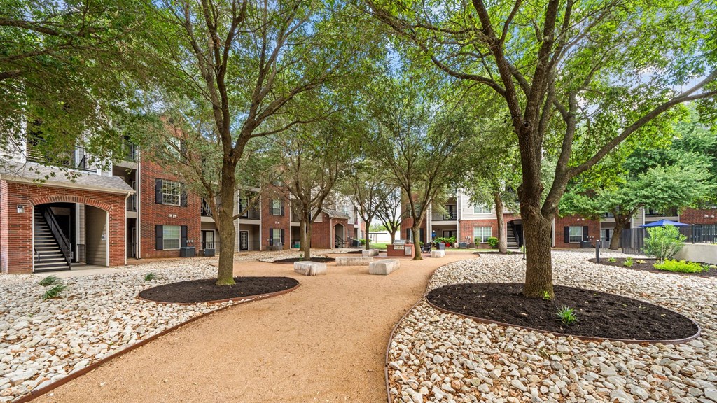 A courtyard with a dirt path and trees.