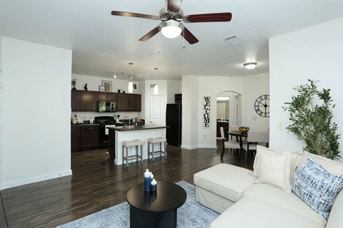 A living room with a white couch and a ceiling fan.