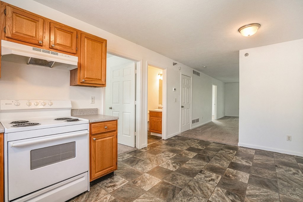 a kitchen with white appliances and wooden cabinets