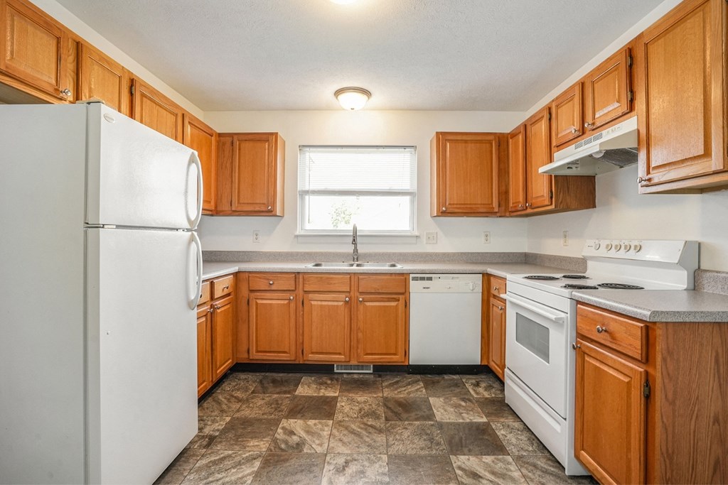 a kitchen with wooden cabinets and white appliances