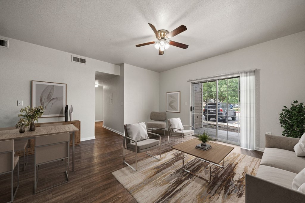 a living room with a ceiling fan and a sliding glass door