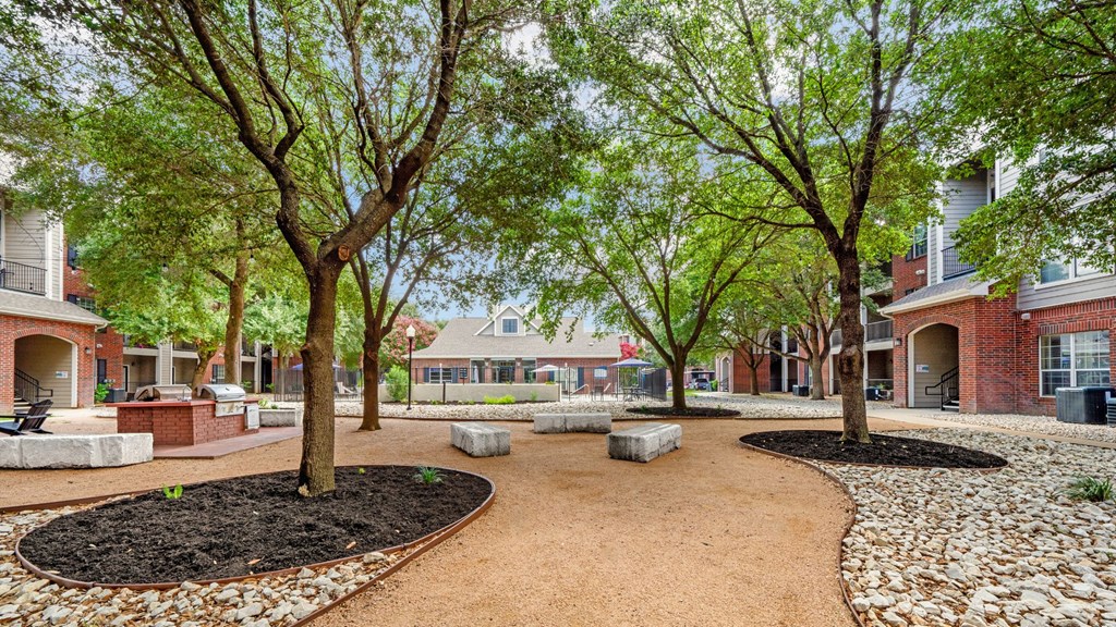 A tree-lined walkway leads to a building.