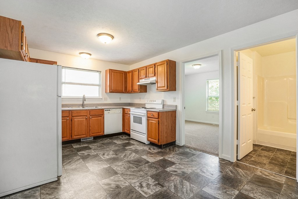 a kitchen with white appliances and wooden cabinets
