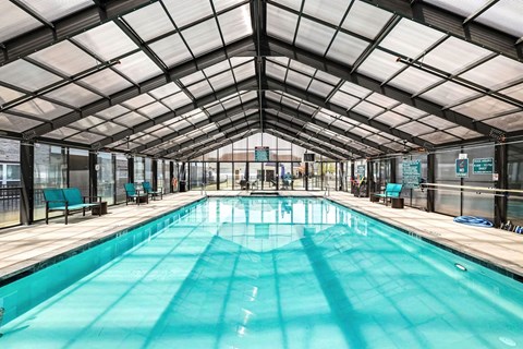 A large indoor swimming pool with a glass ceiling.