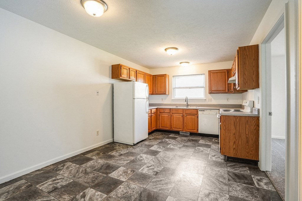 a kitchen with white appliances and wooden cabinets