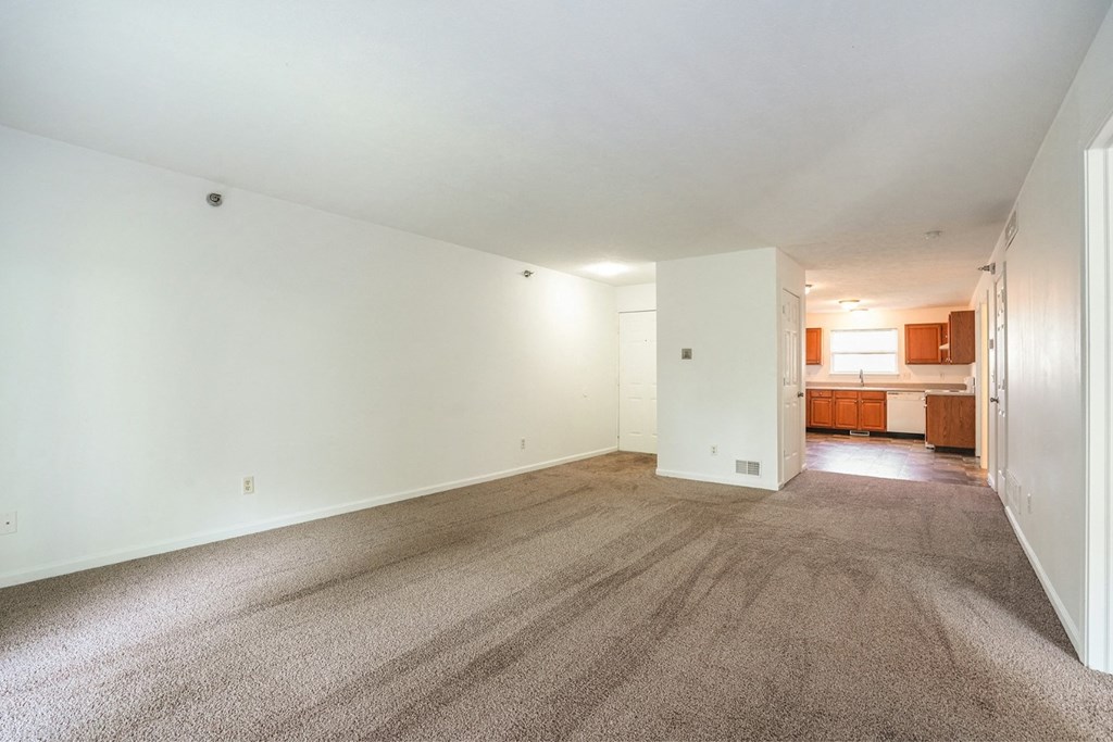 a living room with white walls and carpet
