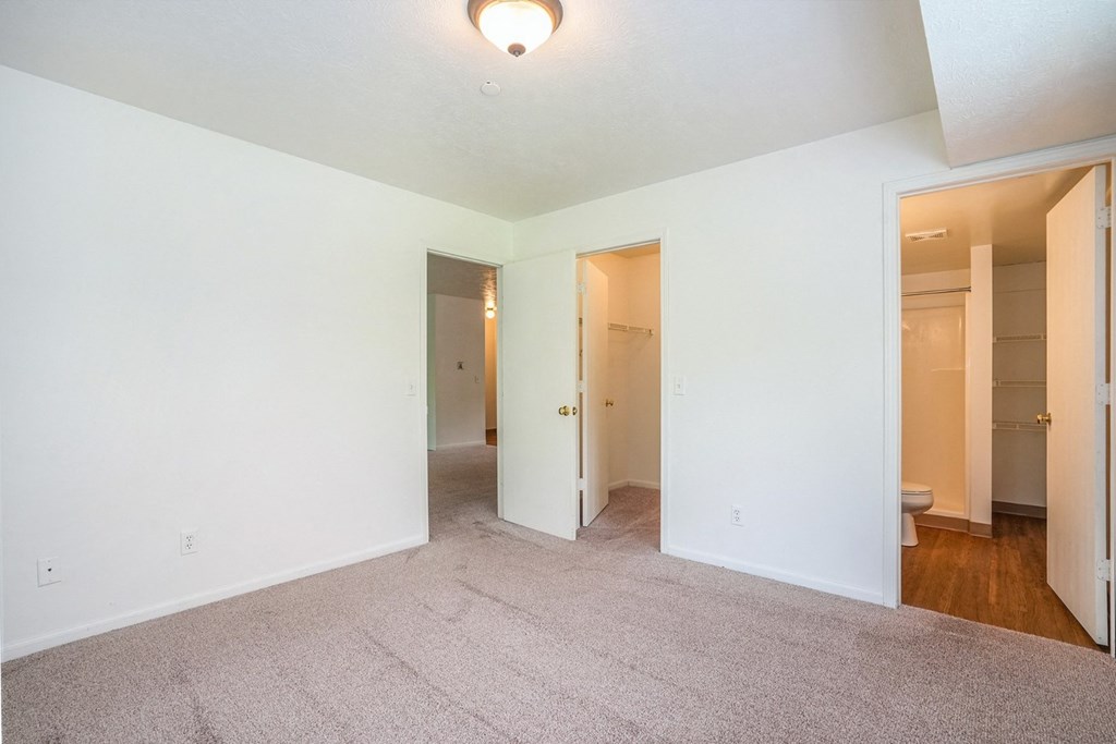 a bedroom with white walls and carpet