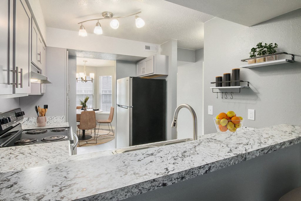 a kitchen with a granite counter top and a stainless steel refrigerator
