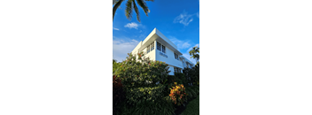 a tall white building with a blue sky in the background