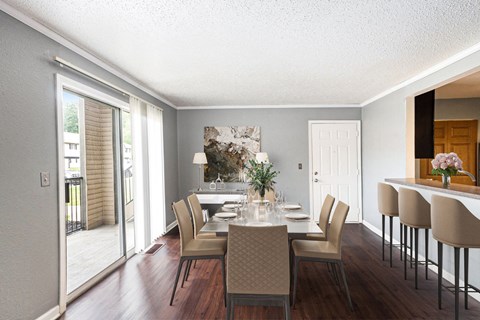 a dining room with a table and chairs and a door to a balcony