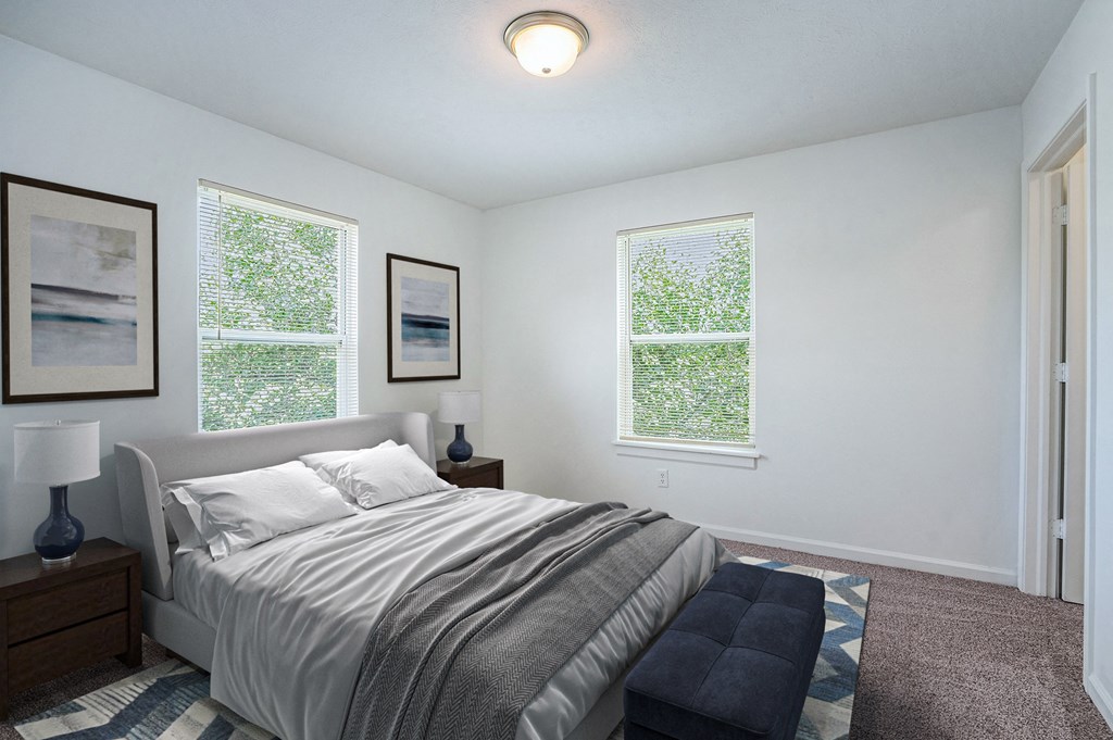 a bedroom with a bed and two windows