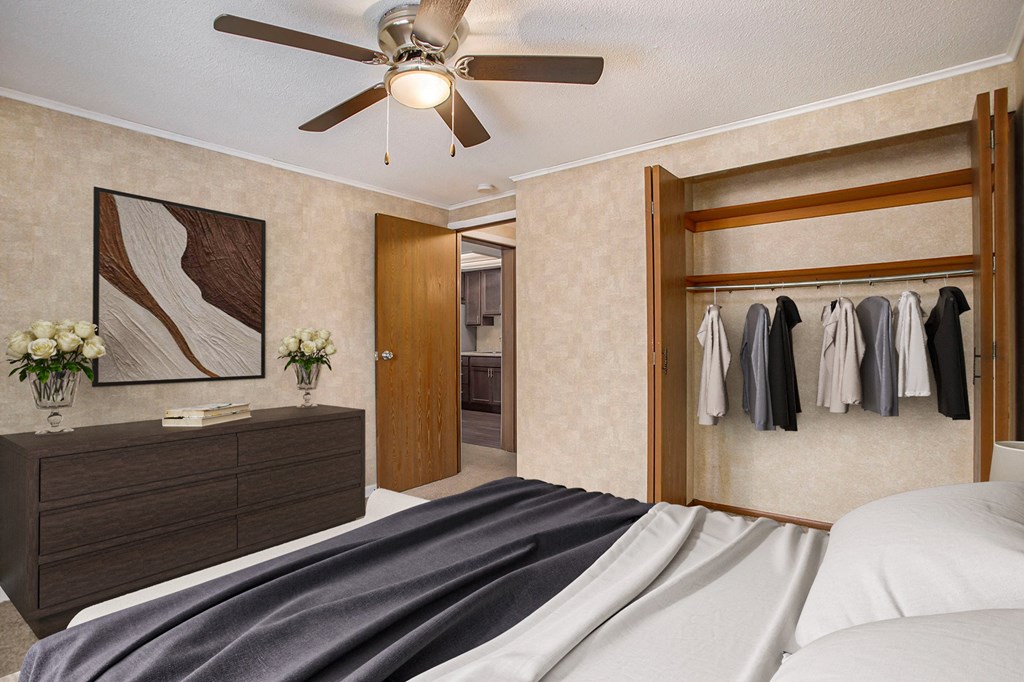 a bedroom with a bed and a ceiling fan and a closet