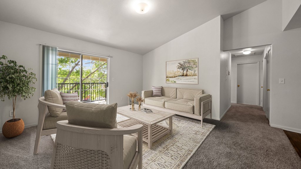 A living room with a white couch, a white chair, and a white coffee table.