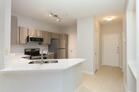 A kitchen with a sink and a refrigerator.