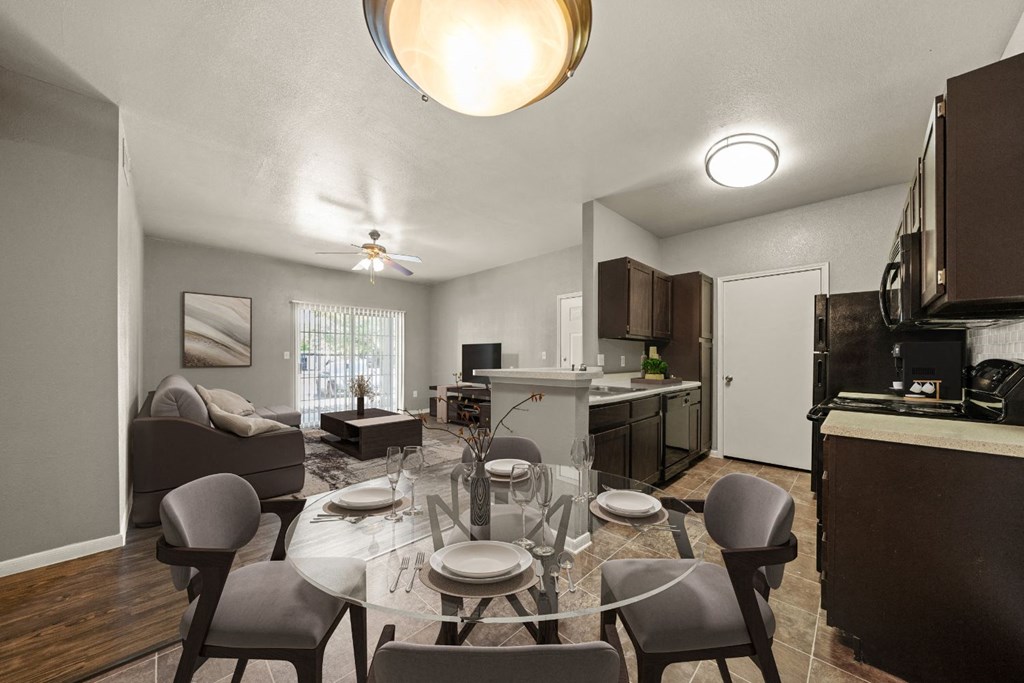 a living room and dining room with a glass table and chairs