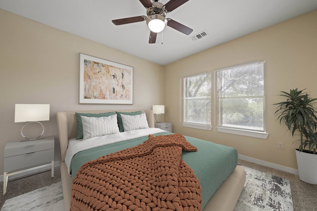a bedroom with a large bed and a ceiling fan