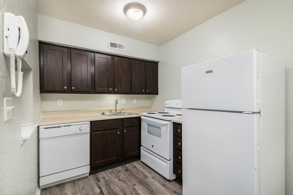 a kitchen with white appliances and dark wood cabinets