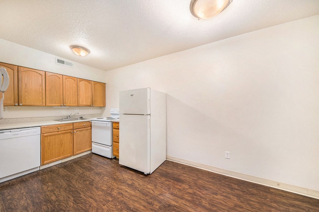 a kitchen with white appliances and wooden cabinets