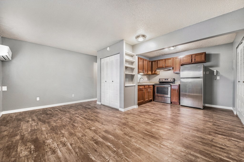 a kitchen and living room with a wooden floor