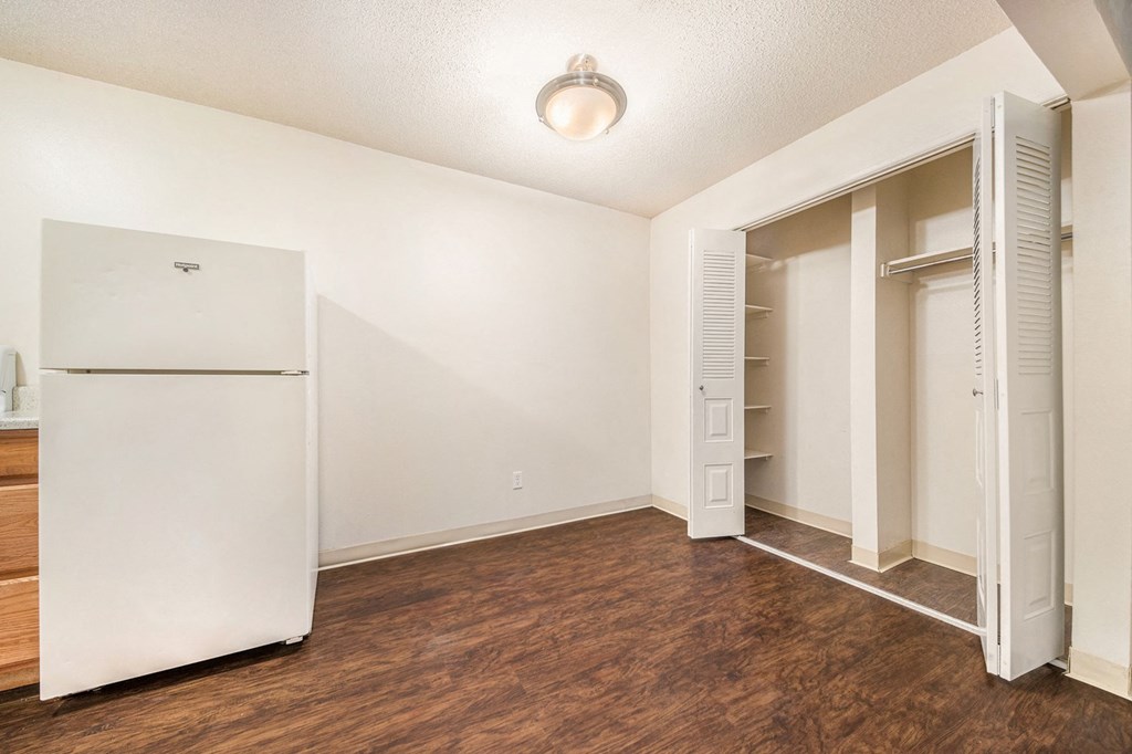 a bedroom with a refrigerator and a closet