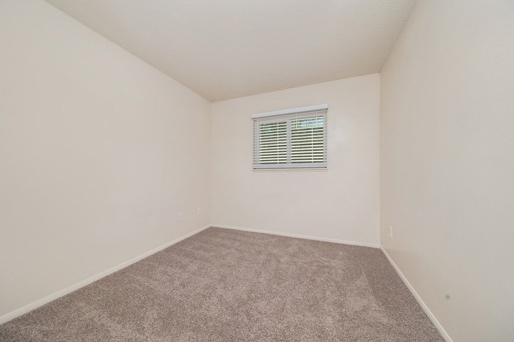 a bedroom with white walls and carpet