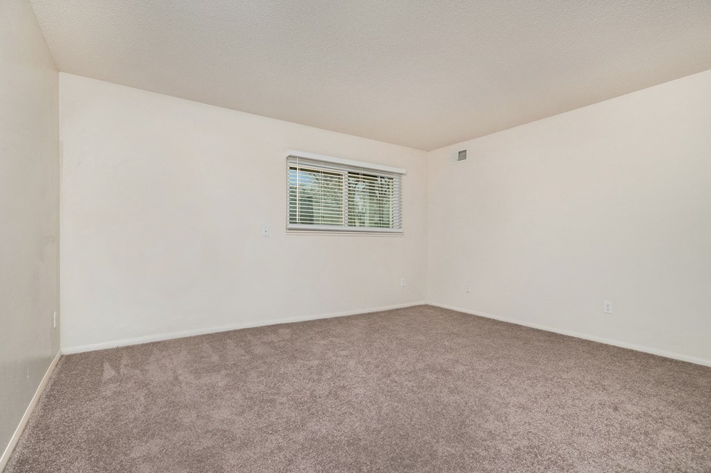 a bedroom with white walls and carpet