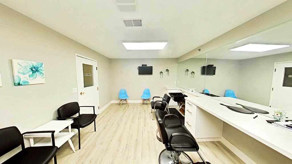A conference room with black chairs and a white table.