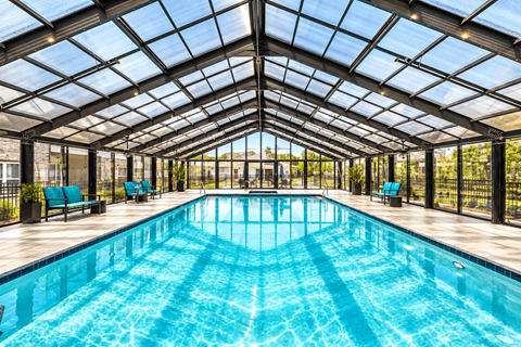 A large indoor swimming pool with a glass ceiling.