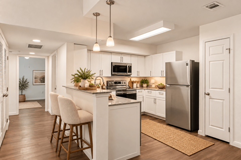 A kitchen with white cabinets and a black refrigerator.