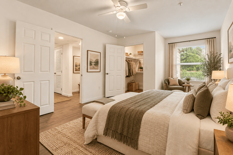 A bedroom with a large bed and a ceiling fan.