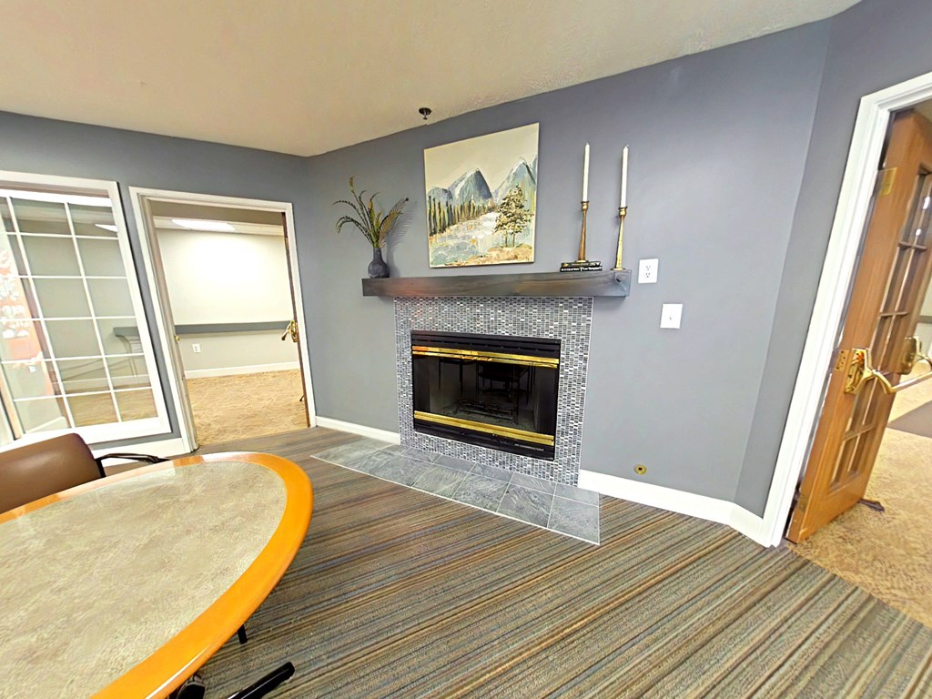 A living room with a fireplace and a painting above it.