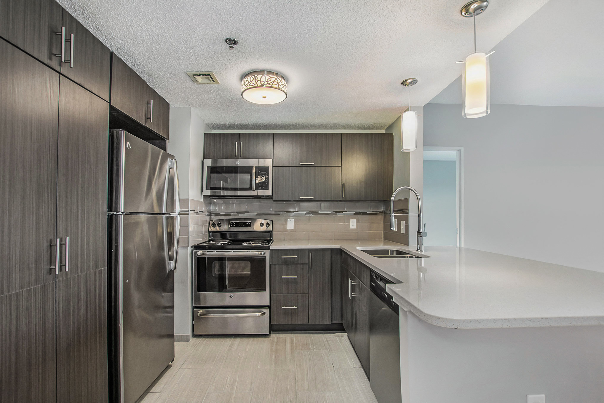 The Plaza Apartments In Grand Rapids, MI Premium Kitchen With Granite Countertops and Wood Style Flooring
