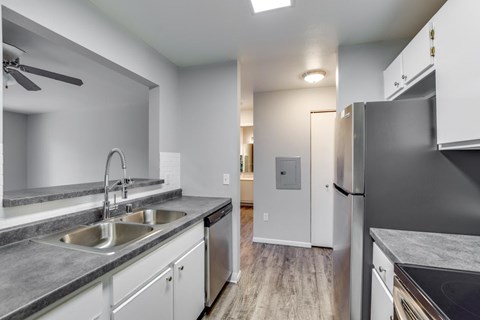 A modern kitchen with a stainless steel refrigerator and a double sink.