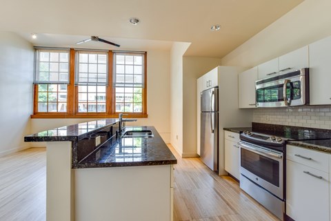 Historic Apartment kitchen with a black countertop and white cabinets.