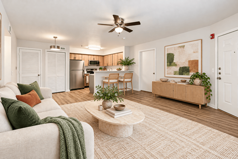 A living room with a couch, a coffee table, and a ceiling fan.