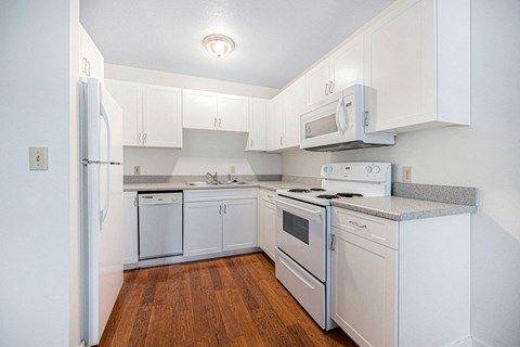 a kitchen with white appliances and white cabinets