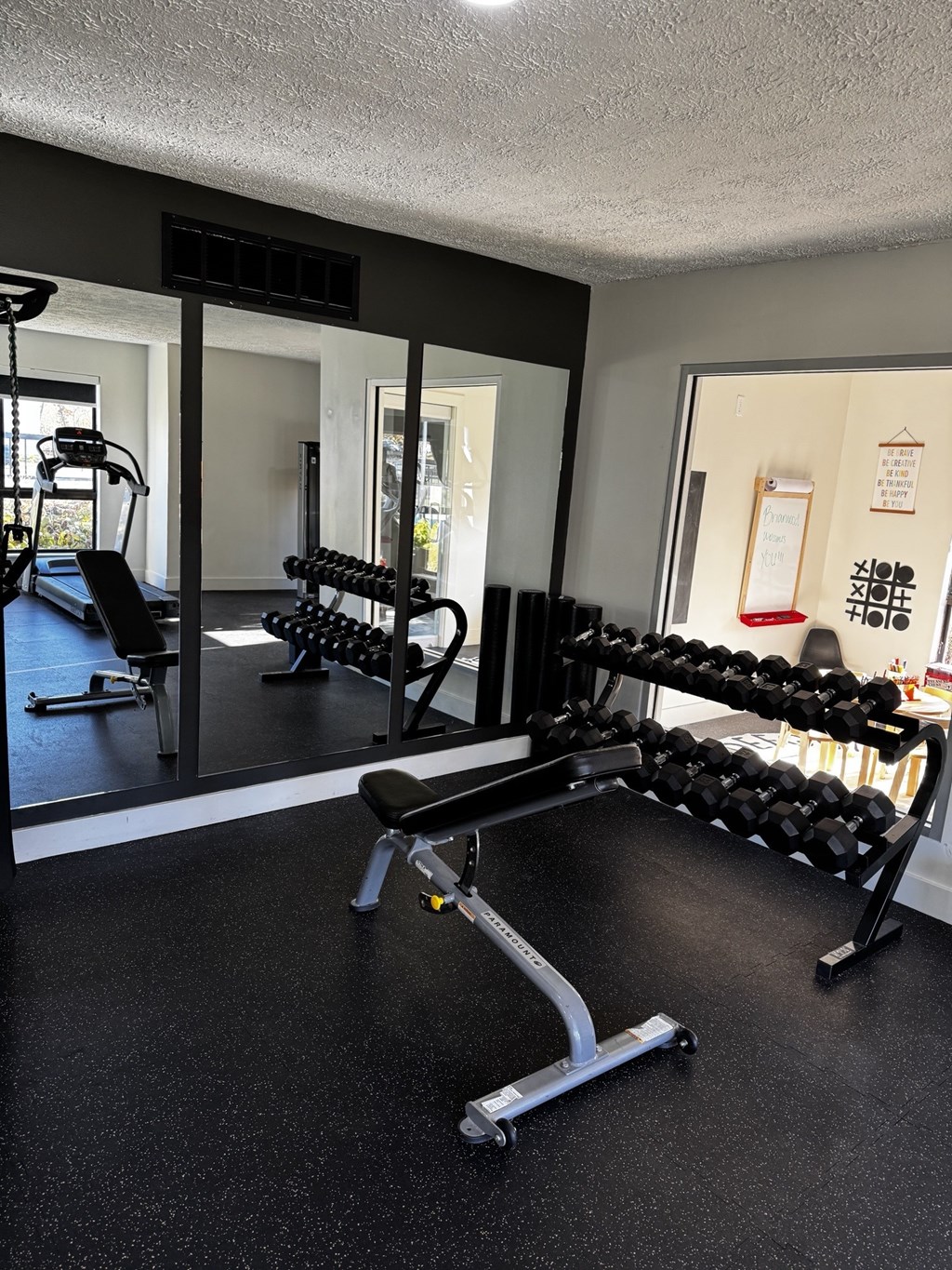 A gym with a row of dumbbells on a rack.