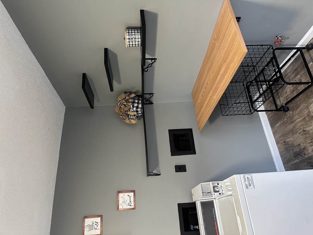A kitchen with a white refrigerator and a wooden shelf above it.