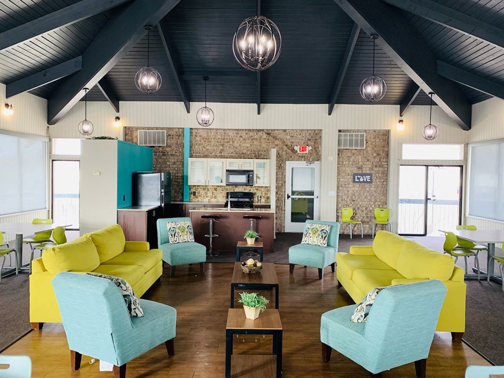 a large living room with yellow couches and blue chairs