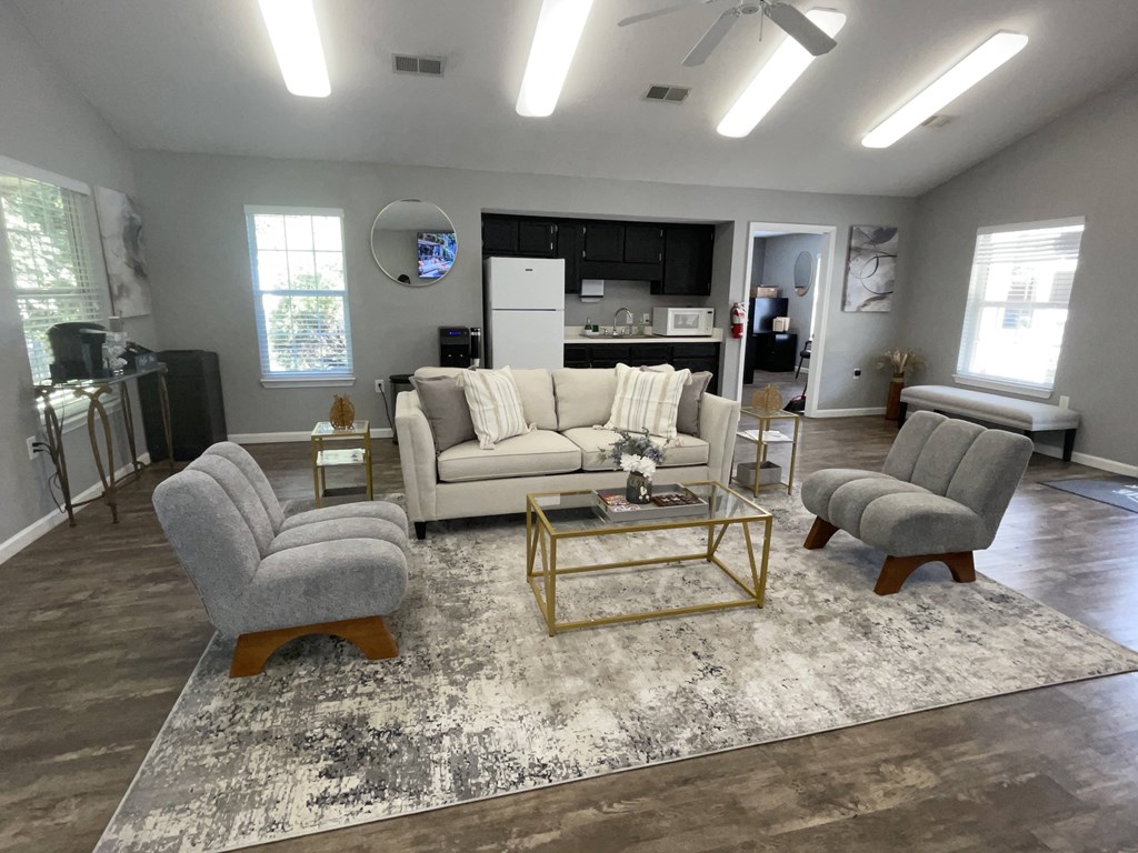 A living room with a white couch, a grey armchair, and a coffee table.