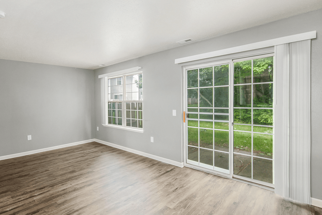 a bedroom with two windows and a door