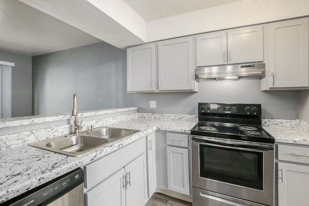 a kitchen with white cabinets and granite countertops