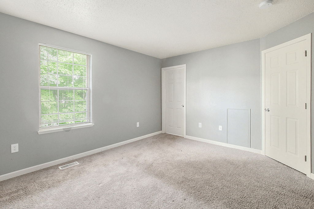 a bedroom with gray walls and a white door