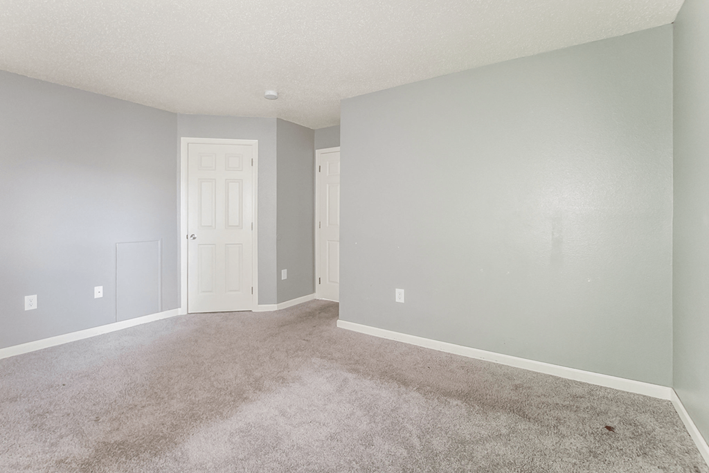 a bedroom with grey walls and carpet